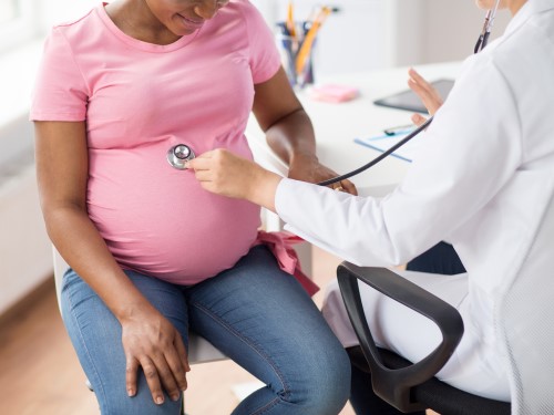 provider with stethoscope on pregnant woman's stomach